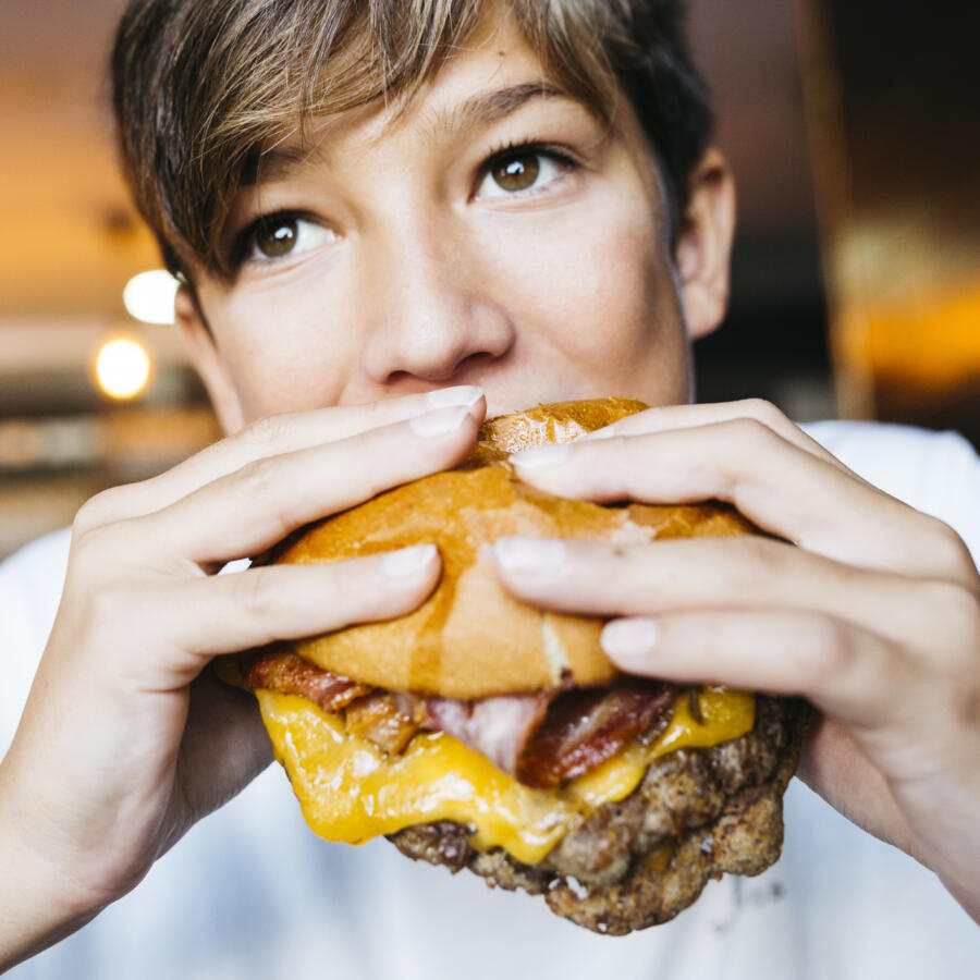 Teenager eating a burger